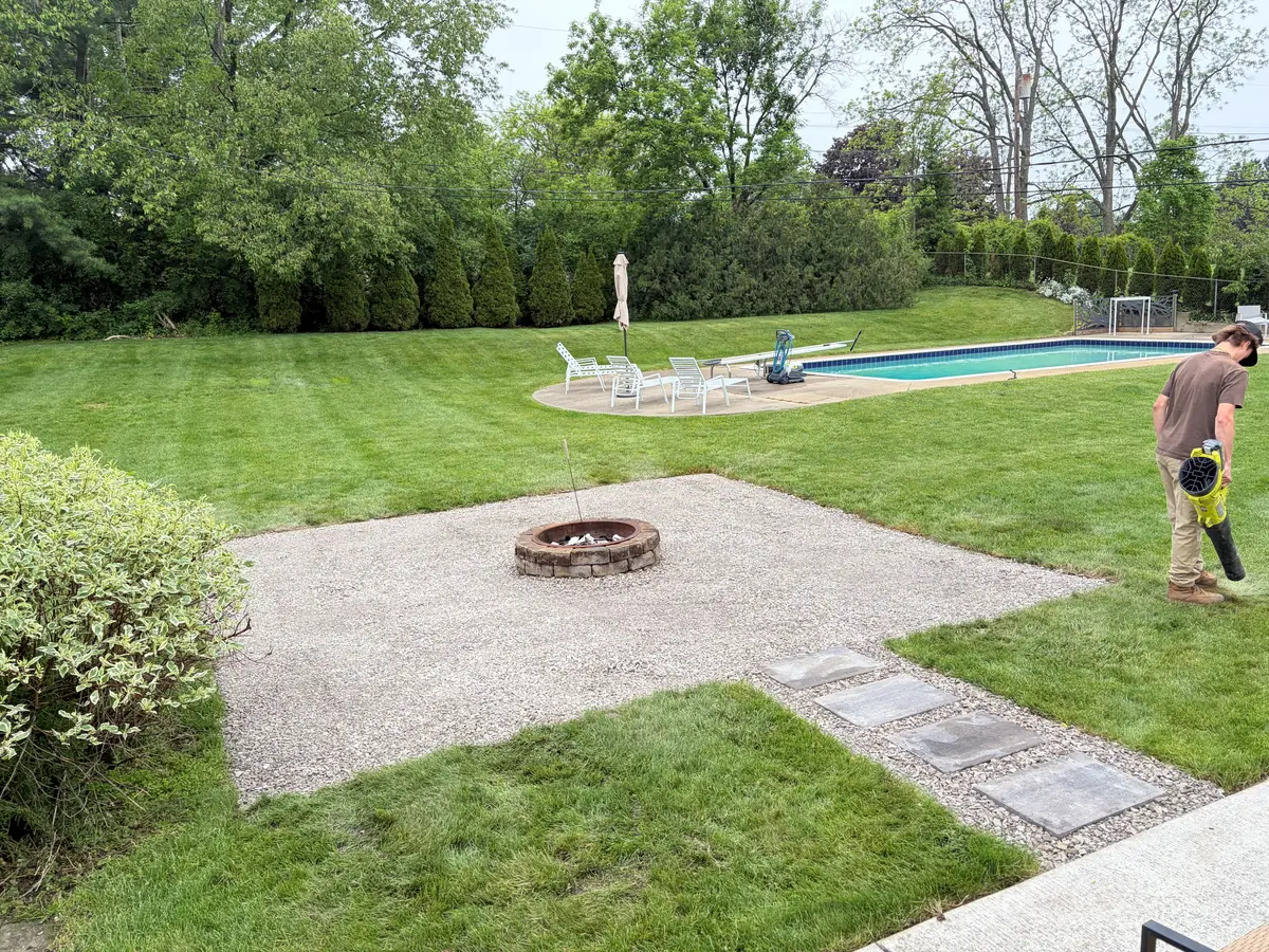 After — Backyard firepit and pea-gravel patio with stepping-stone path