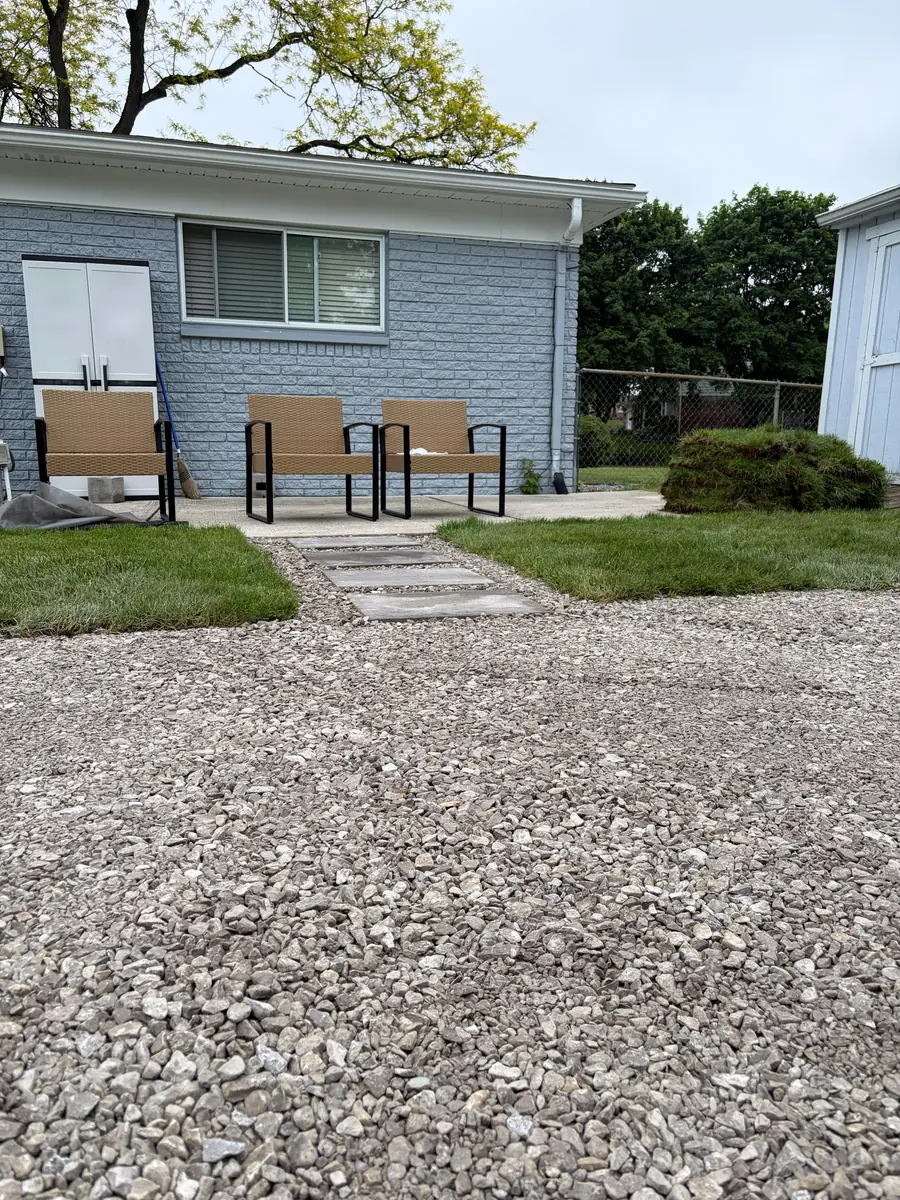 After — Backyard firepit and pea-gravel patio with stepping-stone path